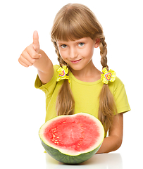 Image showing Little girl is eating watermelon