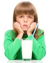 Image showing Gloomy little girl doesn\'t want to drink milk