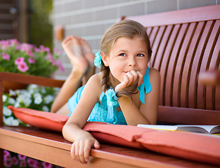 Image showing Little girl is reading a book