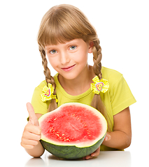 Image showing Little girl is eating watermelon