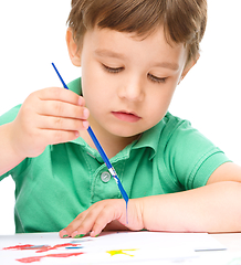 Image showing Little boy is playing with paints