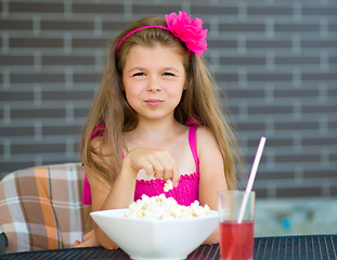 Image showing Little girl is drinking cherry juice