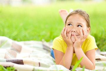 Image showing Portrait of a little girl laying on green grass