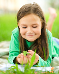 Image showing Portrait of a little girl laying on green grass