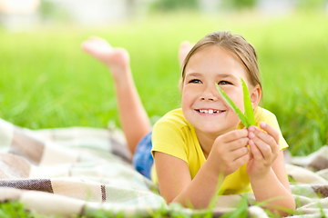 Image showing Portrait of a little girl laying on green grass