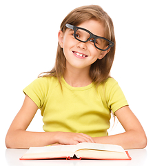 Image showing Little girl is reading a book