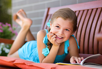 Image showing Little girl is reading a book