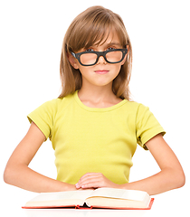 Image showing Little girl is reading a book