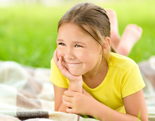 Image showing Portrait of a little girl laying on green grass