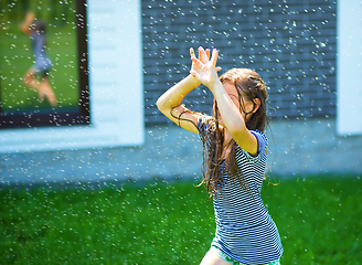 Image showing Happy girl is playing under rain