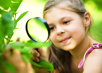 Image showing Girl is looking at tree leaves through magnifier