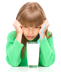 Image showing Gloomy little girl doesn\'t want to drink milk