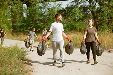 Image showing Group of volunteers tidying up rubbish on beach