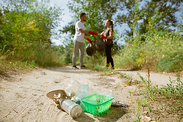 Image showing Group of volunteers tidying up rubbish on beach