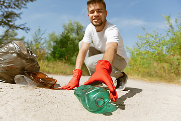 Image showing Volunteer tidying up rubbish on beach