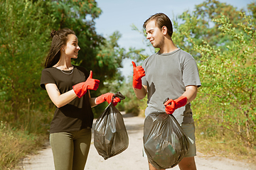 Image showing Group of volunteers tidying up rubbish on beach