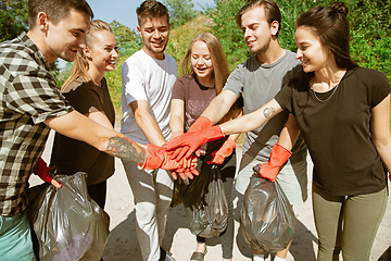 Image showing Group of volunteers tidying up rubbish on beach