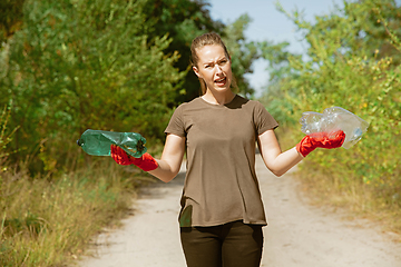 Image showing Volunteer tidying up rubbish on beach