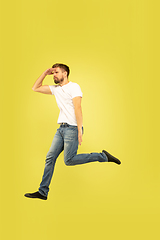 Image showing Full length portrait of happy jumping man on yellow background