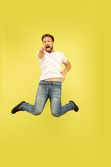 Image showing Full length portrait of happy jumping man on yellow background