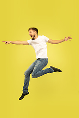 Image showing Full length portrait of happy jumping man on yellow background