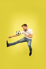 Image showing Full length portrait of happy jumping man on yellow background