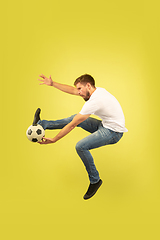 Image showing Full length portrait of happy jumping man on yellow background