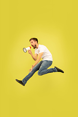 Image showing Full length portrait of happy jumping man on yellow background