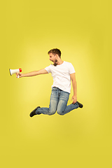 Image showing Full length portrait of happy jumping man on yellow background