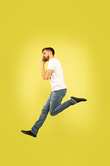 Image showing Full length portrait of happy jumping man on yellow background