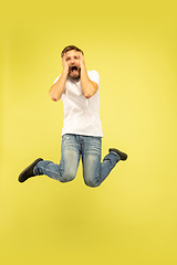 Image showing Full length portrait of happy jumping man on yellow background