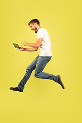 Image showing Full length portrait of happy jumping man on yellow background