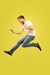 Image showing Full length portrait of happy jumping man on yellow background