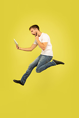 Image showing Full length portrait of happy jumping man on yellow background