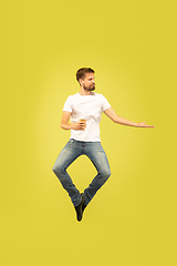 Image showing Full length portrait of happy jumping man on yellow background