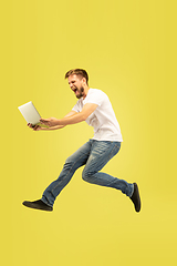 Image showing Full length portrait of happy jumping man on yellow background