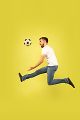 Image showing Full length portrait of happy jumping man on yellow background