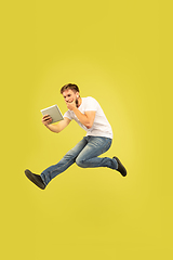 Image showing Full length portrait of happy jumping man on yellow background