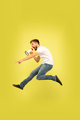 Image showing Full length portrait of happy jumping man on yellow background