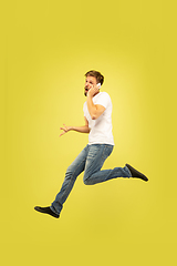 Image showing Full length portrait of happy jumping man on yellow background