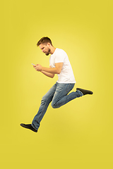 Image showing Full length portrait of happy jumping man on yellow background