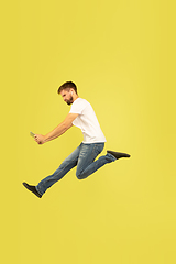 Image showing Full length portrait of happy jumping man on yellow background