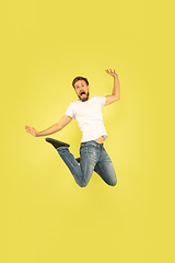 Image showing Full length portrait of happy jumping man on yellow background