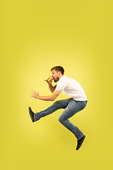 Image showing Full length portrait of happy jumping man on yellow background