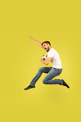 Image showing Full length portrait of happy jumping man on yellow background