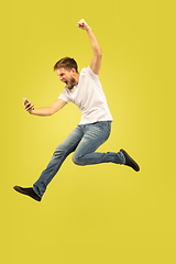 Image showing Full length portrait of happy jumping man on yellow background