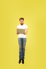 Image showing Full length portrait of happy jumping man on yellow background