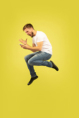 Image showing Full length portrait of happy jumping man on yellow background