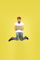 Image showing Full length portrait of happy jumping man on yellow background