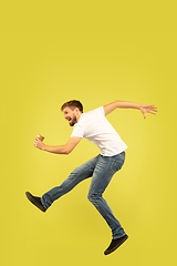 Image showing Full length portrait of happy jumping man on yellow background